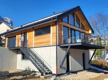 Maison en bois de 127 m² à Saint-Pancrasse avec bardage naturel, terrasse en hauteur et vue sur la Chartreuse.