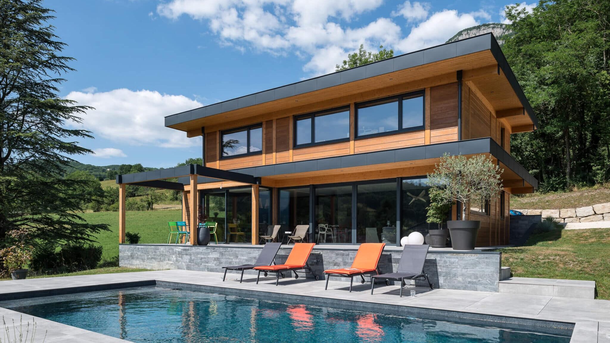 Maison contemporaine en ossature bois avec toiture terrasse et piscine, réalisée par Vision Bois à Saint-Alban-Leysse en Savoie